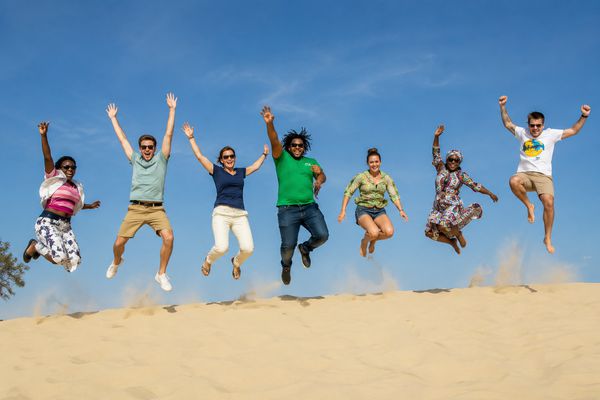 Students jumping on a sand dune in Senegal